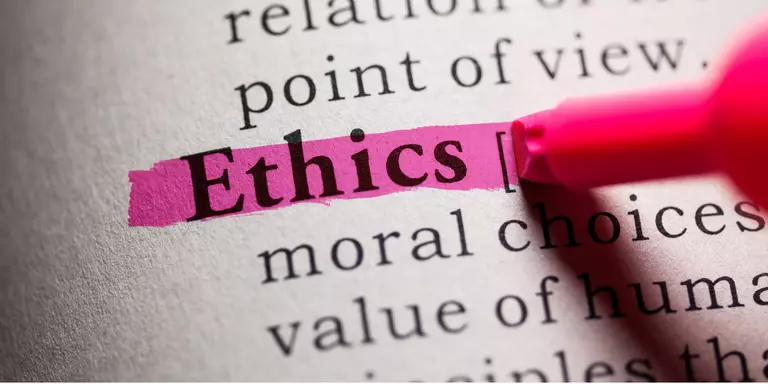 La imagen muestra un texto impreso en una página, donde la palabra "Ethics" está subrayada con un marcador rosa brillante. Esta escena enfatiza el concepto de "ética medioambiental", destacando la importancia de tomar decisiones morales y responsables en relación con el medio ambiente.